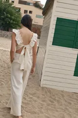 Pantalón palazzo color coral de lino con cintura alta y bolsillos laterales.