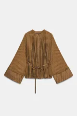 Camisa marrón a rayas con cuello redondo, mangas largas anchas y puños rectos. Cuenta con cierre frontal de botones y un lazo cinturón ajustable del mismo tejido en la cintura.