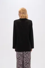 Blazer color beige de lino, con cuello solapa, corte holgado y bolsillos laterales.