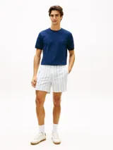 Remera de corte slim color azul marino, con cuello redondo clásico, manga corta y detalle de doble raya en los puños. Presenta el icónico logo bordado de la bandera de Tommy Hilfiger en el pecho.