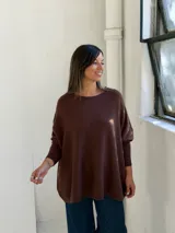 Sweater de punto color chocolate, con cuello redondo, mangas largas con puños ajustados y diseño holgado de corte amplio.