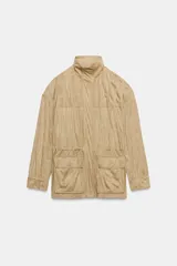 Chaqueta de efecto ante con cuello alto, manga larga y cierre frontal oculto por solapa con botones. Cuenta con bolsillos delanteros de plastrón con solapa y cintura ajustable con cordones.