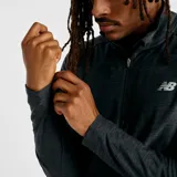 Buzo deportivo New Balance de hombre, modelo Space Dye 1/4 Zip MT41915BKH, color negro jaspeado, con cierre de un cuarto, mangas largas con presillas para el pulgar y logo reflectante.