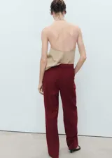 Pantalón de vestir color bordó, de tiro medio y diseño recto con pinzas delanteras. Cuenta con trabillas para cinturón, bolsillos laterales y cierre oculto con botón, gancho y cremallera.