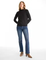 Buzo de punto color beige, con cuello alto y manga larga. Presenta un diseño de tejido liso con detalle de canalé en los hombros y puños.