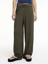 Pantalón de lino color verde militar, con diseño de pierna recta y holgada, cintura elástica y bolsillos laterales.