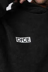 Buzo tipo canguro con capucha, de corte oversize y confeccionado en frisa rústica con efecto lavado. Presenta bolsillo frontal tipo canguro y estampado con texto en el pecho.