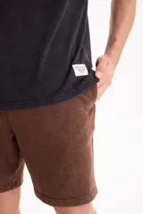 Bermuda de felpa sin friza color marrón con terminación lavada, cintura elastizada con cordón ajustable y corte semi baggy.