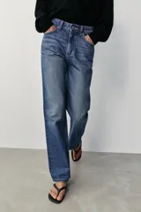 Jeans de tiro alto, pernera recta y larga, estilo clásico con cinco bolsillos, cierre frontal con cremallera y botón metálico.