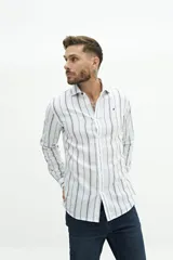 Camisa de manga larga para hombre, color blanco con rayas verticales finas en tonos grises y azules. Confeccionada en una mezcla de lino y algodón, de corte semi slim y logo bordado en el pecho.