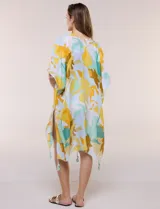 Kimono de gasa ligera con estampado floral en tonos amarillos, celestes, blancos y marrones, de manga corta amplia y diseño abierto con detalle de borlas en el ruedo asimétrico.