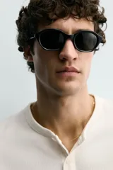 Camiseta de manga corta con cuello panadero y cierre frontal de tres botones. Presenta una textura acanalada y un corte regular fit.