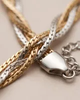 Pulsera de eslabones entrelazados de acero en tonos dorado, plateado y rosado.