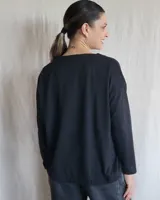 Remera de manga larga confeccionada en lanilla gris melange, con diseño holgado y escote redondo fruncido.