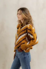 Sweater de punto jacquard con diseño de chevron en tonos celeste y marrón. Presenta cuello redondo, corte holgado y mangas largas con hombros abullonados.