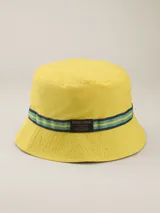 Gorro tipo bucket amarillo con cinta decorativa azul con rayas verde agua y etiqueta con el logo de la marca Benson & Thomas.