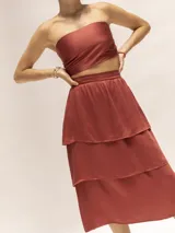 Falda midi negra de seda con cierre invisible lateral, elástico en la cintura y volados.