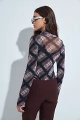 Body de mangas largas con cuello alto, confeccionado en tejido de tul semitransparente con estampado animal print en tonos grises y negros.