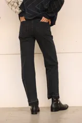 Pantalón de jean recto color negro con detalle desflecado en los tobillos.