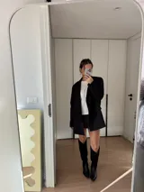 Botas texanas de caña alta, confeccionadas en cuero negro, con taco cuadrado de 5 cm y punta fina.