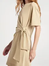 Vestido corto de manga corta con cuello redondo y detalle de lazo anudado en la cintura, confeccionado en tejido suave.