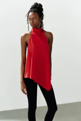 Top halter asimétrico de color rojo, confeccionado en tejido elástico, con cuello alto y cierre posterior con botones.