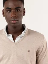 Sweater de punto color camel con escote en V, manga larga y el logo de la marca bordado en el pecho.