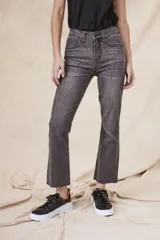 Pantalón de jeans gris oscuro, de corte flare, tiro alto y terminación desflecada.
