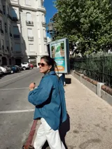 Camisa de jean celeste, de corte holgado, con cuello camisero, cierre frontal con botones y bolsillo de parche en el pecho.