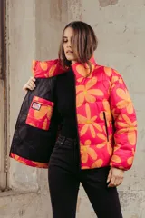 Campera puffer acolchada con estampado floral en tonos fucsia y naranja, cuello alto y cierre frontal.