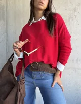 Sweater de tejido de punto en color rojo, con cuello redondo y mangas largas. Presenta un diseño holgado y cómodo.