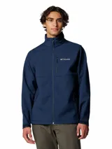 Chaqueta softshell Columbia para hombre, color azul marino, con cierre frontal, cuello alto y múltiples bolsillos con cremallera. Presenta puños y dobladillo ajustables.