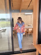 Camisa oversize combinada de denim azul y tela vintage con estampado geométrico multicolor en tonos rojos, naranjas y celestes. Cuenta con cierre frontal de botones, cuello camisero y mangas largas.