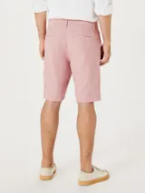 Bermuda de sarga modelo chino, color rosado, con cierre de botón y cremallera, bolsillos laterales y corte recto.