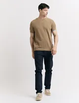 Remera de punto color beige, de manga corta y cuello redondo.