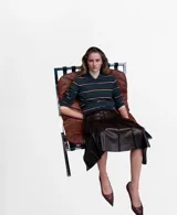 Falda midi plisada de cuero sintético en color marrón oscuro, con diseño acampanado y talle alto.