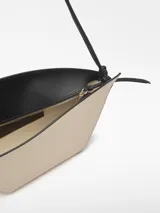 Bolso de hombro Adolfo Dominguez modelo Eclipse, confeccionado en piel bovina color tostado. Presenta un diseño estructurado formado por dos piezas asimétricas entrecruzadas, cierre con cremallera, asa de hombro extraíble y logo grabado en la parte frontal.