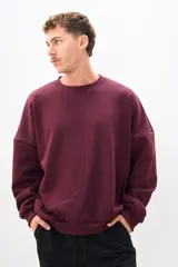 Buzo de cuello redondo color bordó, de corte amplio y mangas largas.