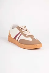 Championes deportivos para mujer Paddock modelo Aegon, con diseño en color blanco, detalles en beige y marrón tostado, y franjas laterales oscuras. Cuenta con suela de goma color camel y cordones blancos.