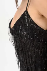 Vestido corto negro con tirantes finos, escote en V y diseño completamente revestido de flecos brillantes.