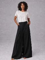 Pantalón de vestir sastrero color negro, de corte recto y pierna ancha, con pinzas frontales y bolsillos laterales.