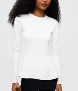 Blusa peplum de manga larga en punto roma color blanco, con cuello redondo y diseño estructurado de corte amplio en el ruedo.