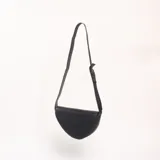 Bandolera de diseño semicircular en color negro, con correa larga ajustable y cierre superior.