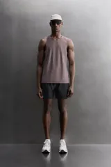 Musculosa deportiva Zara Athleticz de tejido ligero y elástico con paneles laterales de malla transpirable. Presenta cuello redondo, sisas amplias y bajo con aberturas laterales.