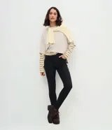 Pantalón skinny de tiro alto, confeccionado en denim negro con cierre de botón y cremallera. Cuenta con trabillas en la cintura y bolsillos funcionales tanto en la parte frontal como en la trasera.