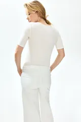Top de jersey acanalado color blanco off-white, con escote en V profundo adornado con encaje y mangas cortas.