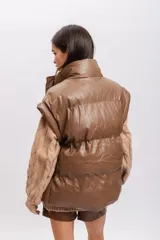Chaleco puffer marrón de cuero sintético con cuello alto y cierre frontal con botones a presión.