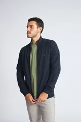 Campera tejida de algodón con cierre frontal completo, cuello alto y mangas largas. Presenta un diseño básico con logo bordado en el pecho.