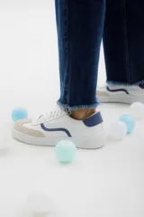 Zapatillas bajas con estampado animal print de leopardo, cordones negros y suela blanca.