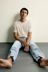 Jeans de corte recto en tono azul clásico con efecto lavado, tiro medio y diseño de cinco bolsillos con cierre frontal de botones.